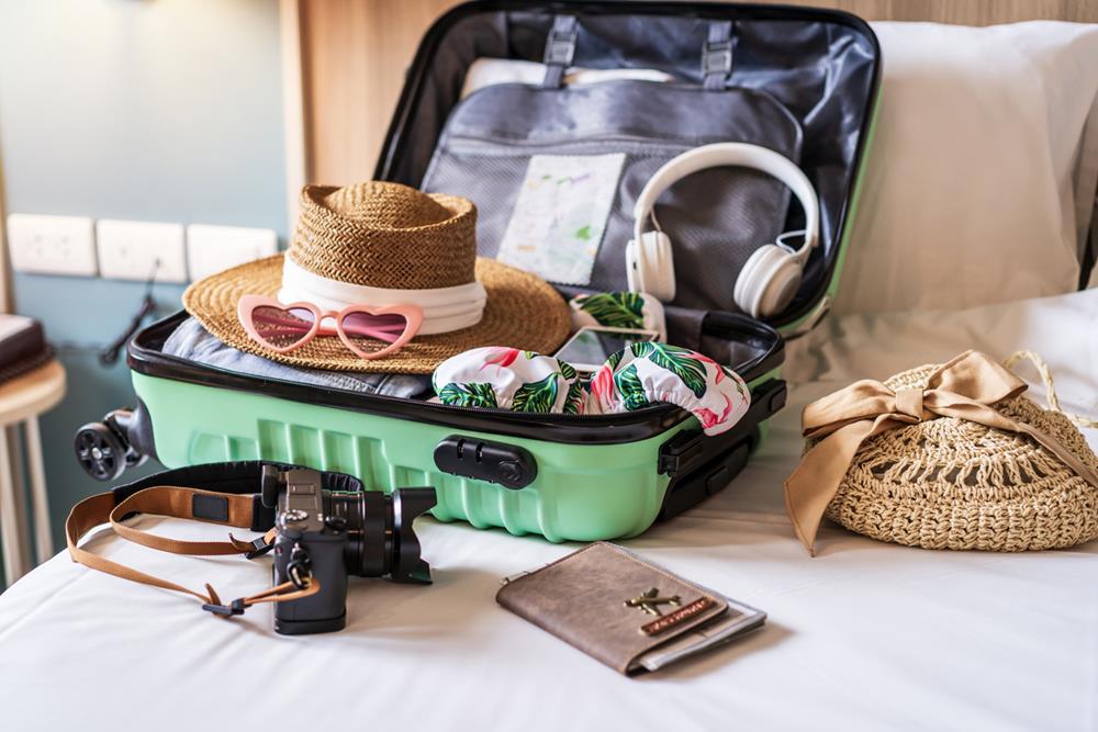 Traveler suitcase and luggage with travel accessories and items being prepared for travel