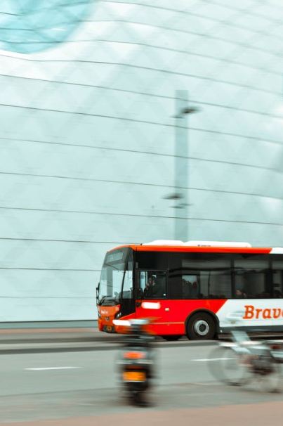selective-focus-photography-of-red-and-white-bus