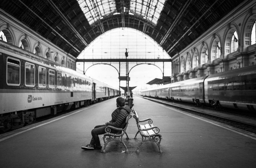 man sitting on the bench in a train station