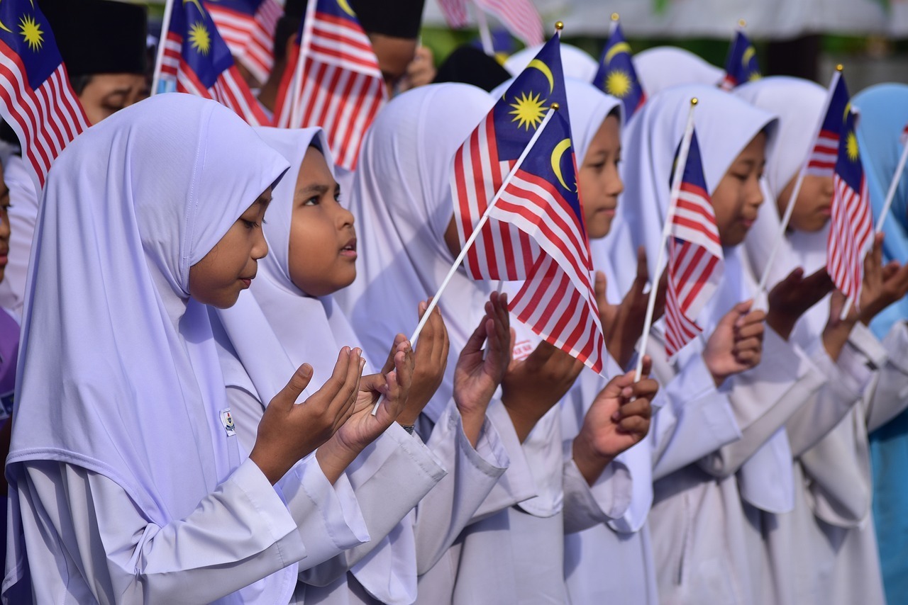 children waving Malaysia’s flag